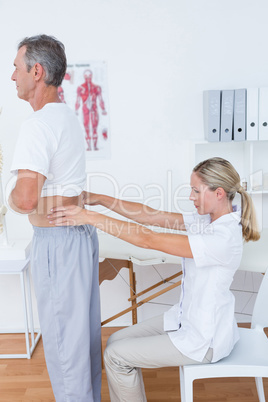 Doctor examining her patient back