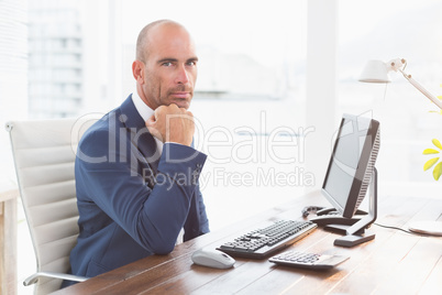 Businessman looking at camera at his desk