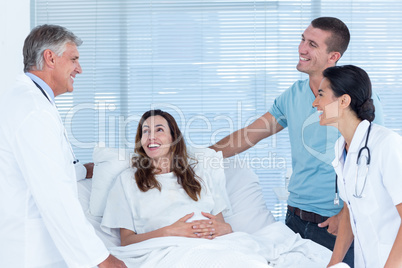 Future parents talking with smiling doctors