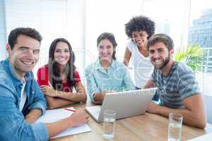 Colleagues using laptop at office