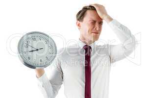 Anxious businessman holding a clock
