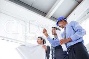 Businessman explaining a blueprint to his colleagues
