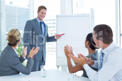 Manager presenting whiteboard to his colleagues