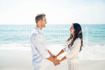 Couple holding hands and standing at beach