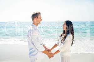 Couple holding hands and standing at beach