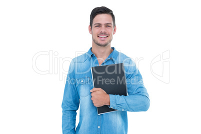 Handsome hipster smiling at camera and holding book