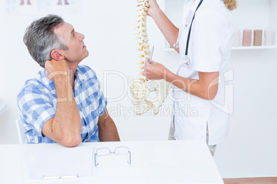 Doctor showing anatomical spine to her patient