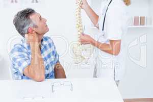 Doctor showing anatomical spine to her patient