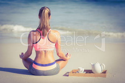 Fit woman doing yoga on the beach