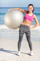 Happy fit woman holding exercise ball