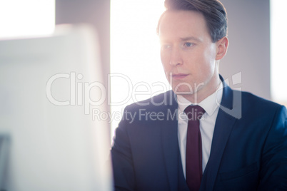 Serious businessman typing on computer