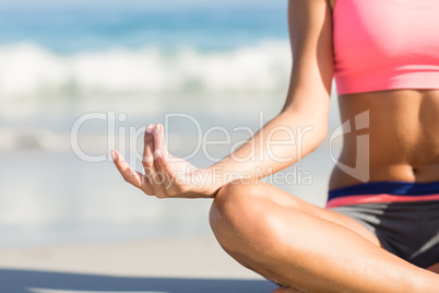 Close up view of fit woman doing yoga beside the sea