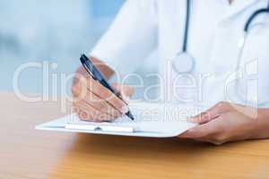 Doctor holding clipboard with file