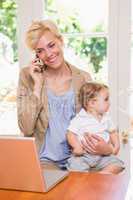 Blonde woman with his son using phone and laptop
