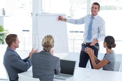 Manager presenting whiteboard to his colleagues