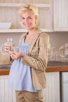 Smiling blonde pregnancy taking a vitamin