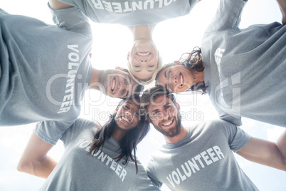 Happy volunteers forming huddle