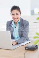 Smiling businesswoman using her computer