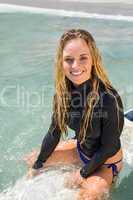 Woman on a surfboard smiling at camera