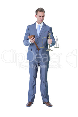 Businessman holding hammer and balance