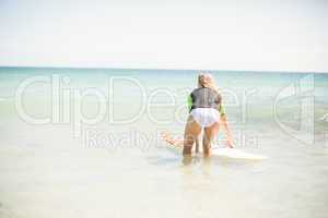 Wear view of pretty blonde preparing to surf