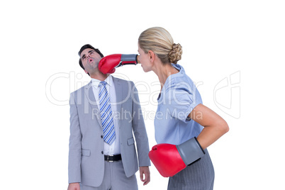 Businesswoman punching colleague with boxing gloves