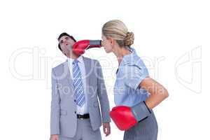 Businesswoman punching colleague with boxing gloves