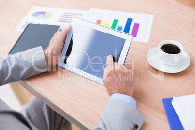 Concentrating businessman using a tablet