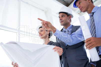 Businessman explaining a blueprint to his colleagues