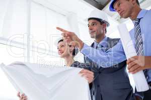 Businessman explaining a blueprint to his colleagues