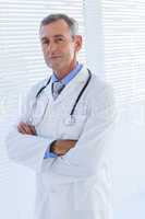 Confident male doctor looking at camera with arms crossed