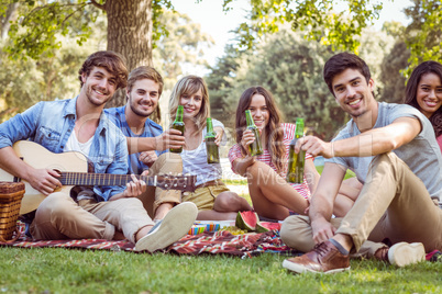 Happy friends in the park having picnic