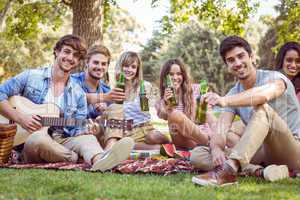 Happy friends in the park having picnic