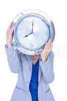 Businesswoman hiding her head with clock