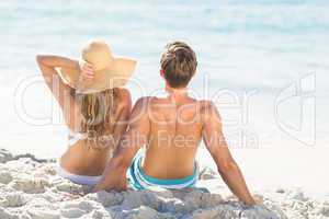 Happy couple relaxing together in the sand