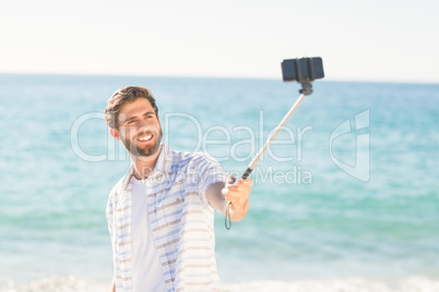 Happy man taking selfie with selfie stick