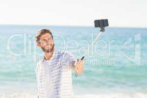 Happy man taking selfie with selfie stick
