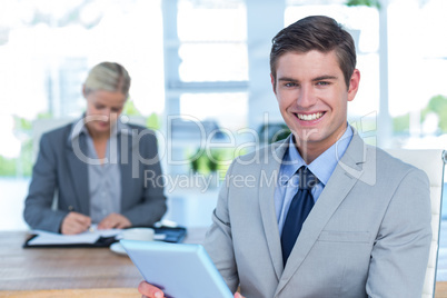 Smiling businessman looking at camera and holding a file