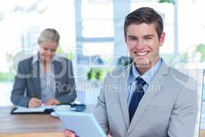 Smiling businessman looking at camera and holding a file