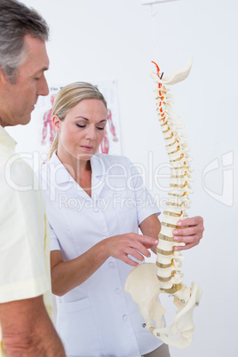 Doctor showing her patient a spine model