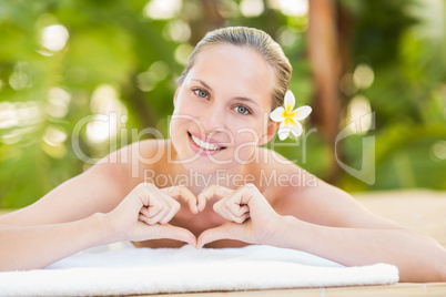 Peaceful blonde lying on towel looking at camera