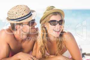 Happy couple relaxing together in the sand