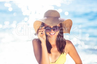 Brunette relaxing with a straw hat smiling at camera