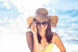 Brunette relaxing with a straw hat smiling at camera