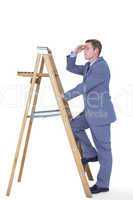 Composite image of businessman standing on ladder looking