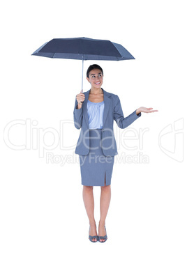 Businesswoman holding umbrella while testing if it rains