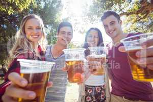 Happy friends in the park having beers