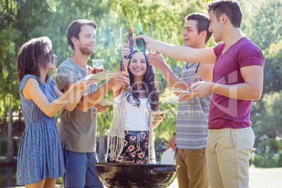 Happy friends in the park having barbecue