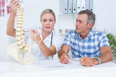 Doctor showing anatomical spine to her patient