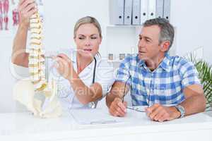 Doctor showing anatomical spine to her patient